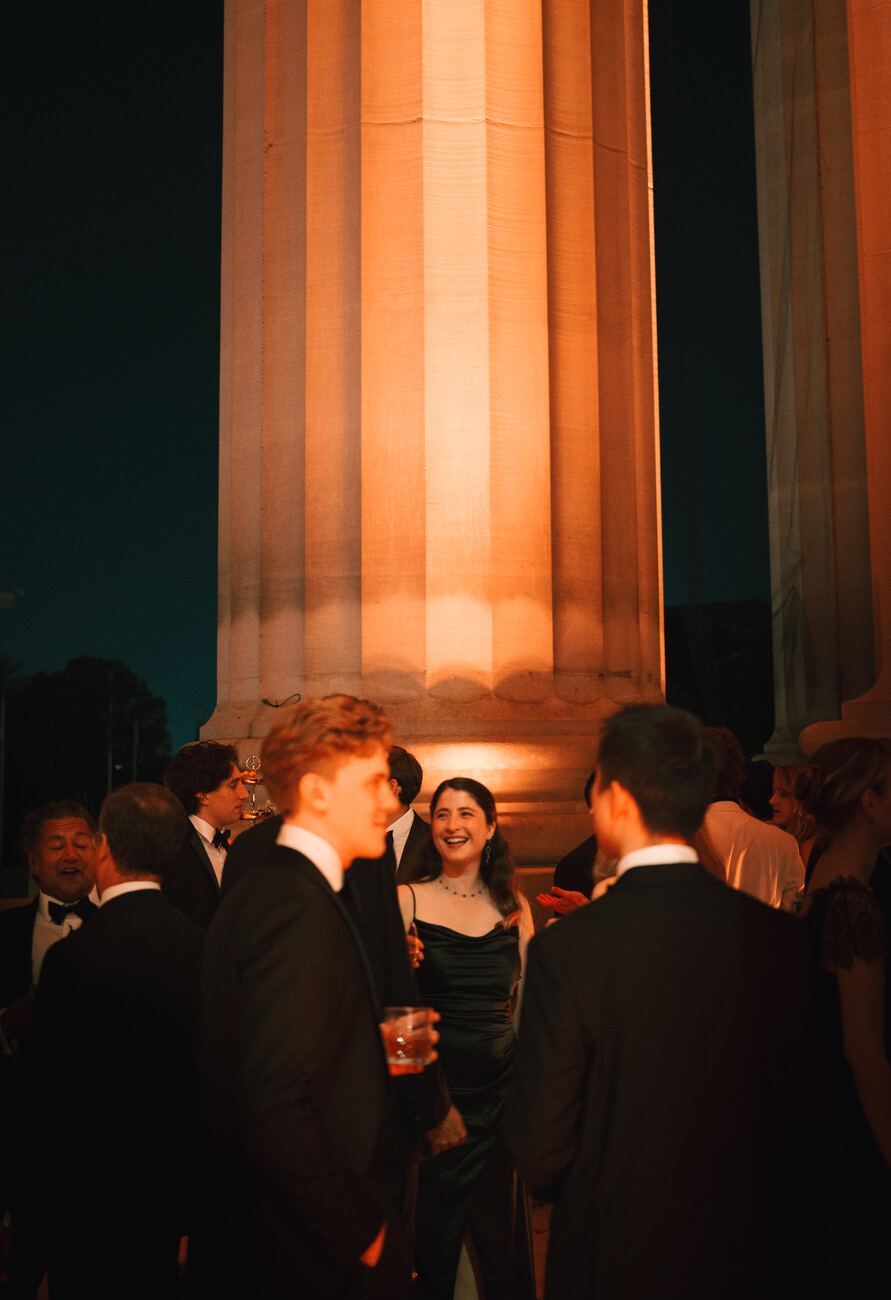 Guests among the lit columns after dark
