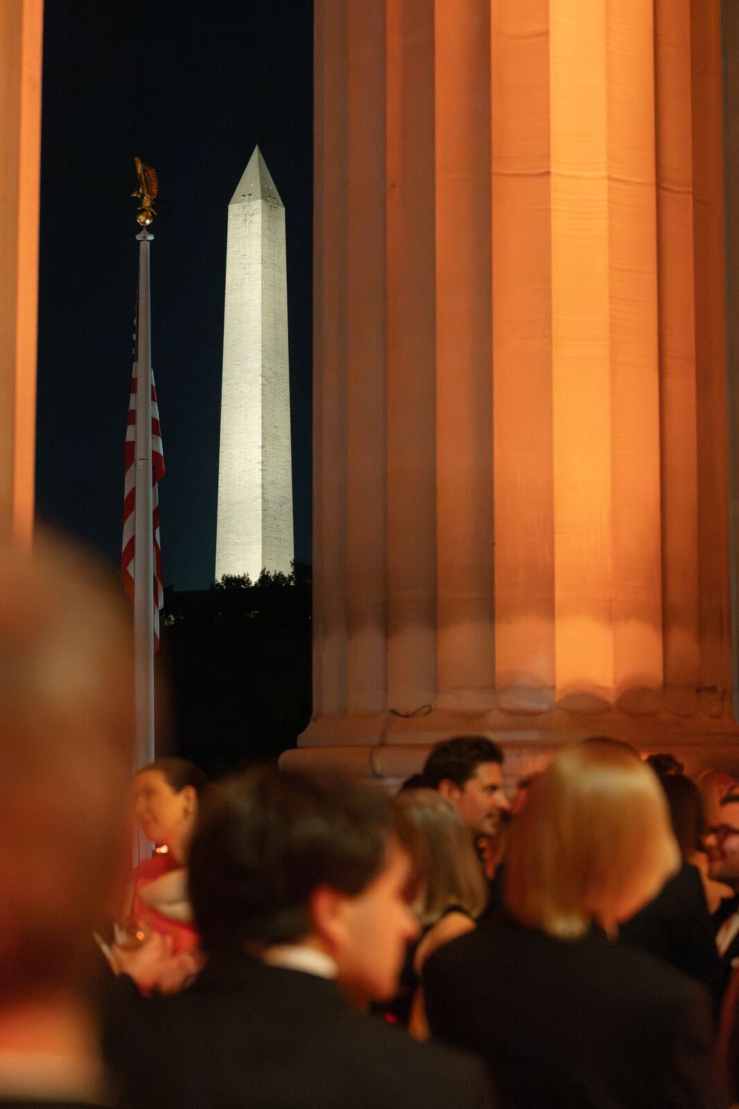 Guests on the portico at night, with the Washington Monument beyond